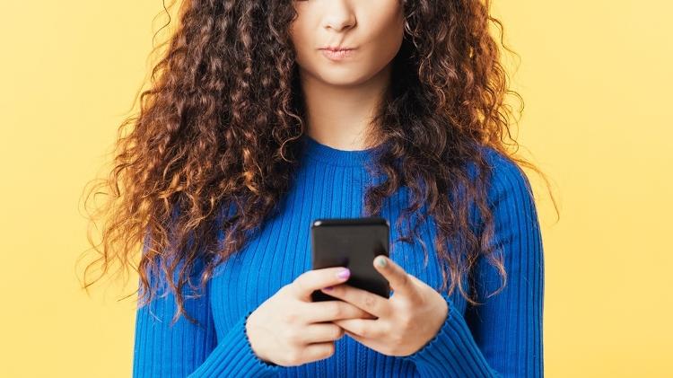 Mulher olhando para celular, falando sobre o impacto que afeta o vírus, rede social - golubovy / Getty Images / iStockphoto - golubovy / Getty Images / iStockphoto